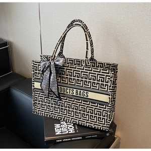 Detail view of the geometric maze pattern canvas tote bag with silk scarf on art books