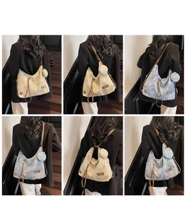 Detail view of large Hobo tote bag with adjustable brown strap and matching coin purse charm