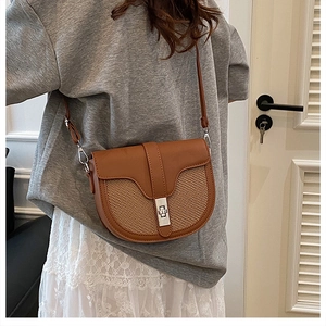 Brown contrast saddle bag with woven texture worn by a model in a casual indoor setting