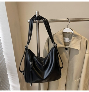 Detail of black matte leather tote bag with FASHION & BAGS lettering and side tassels