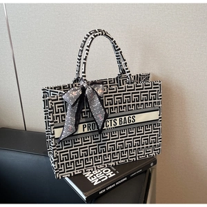 Detail of canvas tote bag with black and white geometric pattern and decorative silk scarf