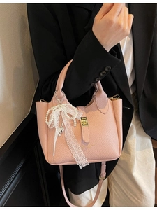 Pink lychee grain bucket bag with lace bow and pearl charm for crossbody carry