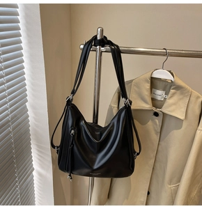 Detail of a black minimalist tote bag with silver hardware and fashion lettering