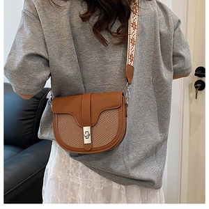 Detail of saddle bag with color-block weave and ethnic style wide woven shoulder strap
