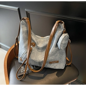 Detail of blue canvas tote bag with brown faux leather straps and a round coin purse
