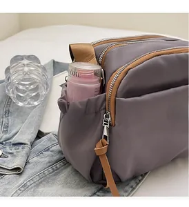 Detail view of durable side pocket and large storage capacity on dark gray crossbody bag