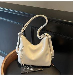 Detailed shot of cream PU leather hobo bag with tassel zipper and fashion embossing
