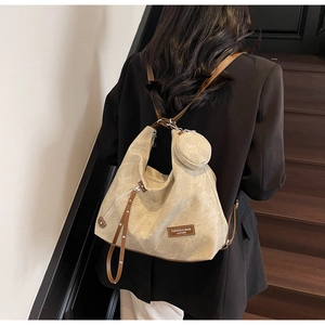 Detail view of retro beige canvas backpack with brown leather straps on a model back