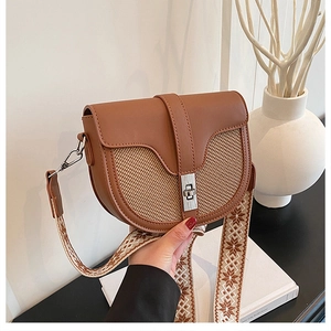Detailed close-up of brown leather saddle bag with woven texture and ethnic strap