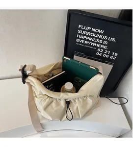 Spacious interior of the pleated cream crossbody bag holding a tablet and daily essentials