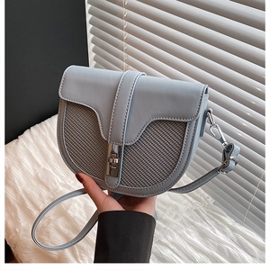 Close-up of contrast saddle bag showing smooth leather texture and metal swivel lock