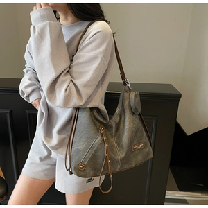 Detail of vintage grey tote bag with brown leather straps and side zipper compartment