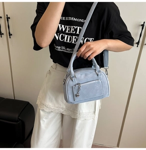 Borsa bowling azzurra con ciondolo a cuore indossata a tracolla per l'uso quotidiano
