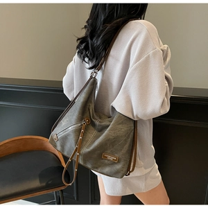 Detail of vintage canvas hobo bag with contrast stitching and leather brand patch