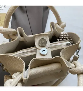 Detail of lychee pattern leather handbag showing magnetic buckle and zipper closure