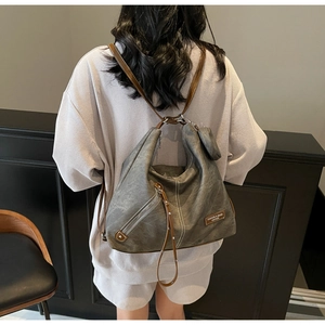 Detail of grey convertible backpack showing vintage leather texture and diagonal zipper