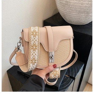 Detail of cream crossbody bag with woven texture and ethnic embroidered wide strap