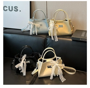 Detail of bow-knot shoulder bags in light blue, yellow, black and beige faux leather