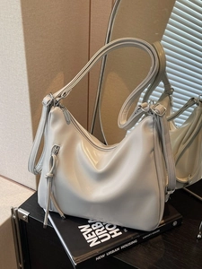 Minimalist light grey hobo bag with dual straps and brand logo on premium leather surface
