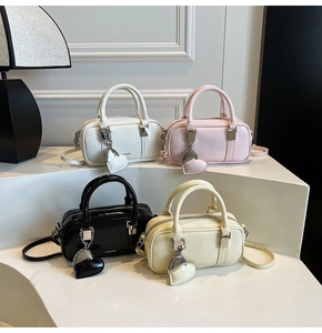 Row of stylish boston handbags in white, pink, black and yellow with heart charms