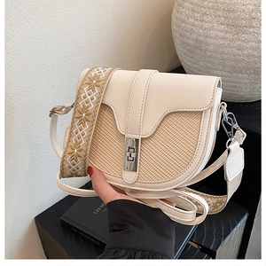 Close-up of contrast-colored saddle bag with woven texture and ethnic strap