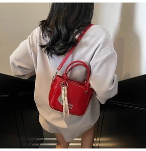 Sac seau rouge porté en bandoulière vue de dos avec détails de lettres métalliques