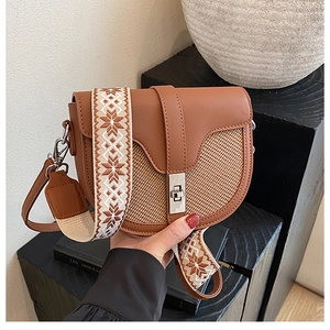 Detail of saddle bag featuring retro brown leather with woven texture and ethnic strap