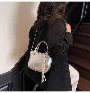 Sac seau argenté avec lettrage COIN RUN et pompon rose porté par un mannequin