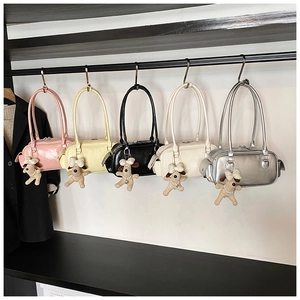 Détail de sacs polochons élégants en cinq couleurs avec pendentif chiot en peluche