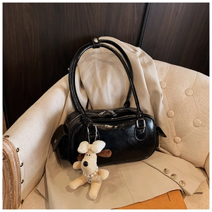 Détail du sac polochon noir brillant avec fermetures éclair et pendentif chien peluche