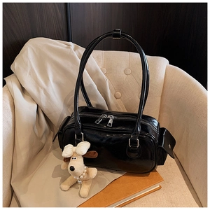 Détail d'un sac oreiller noir brillant avec doubles fermetures éclair et charmant chien beige