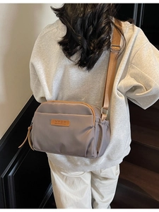 Taupe nylon crossbody bag with multi-zipper compartments and adjustable wide strap