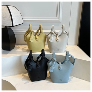 Borse a secchiello in pelle con motivo litchi in giallo, bianco, nero e blu in mostra
