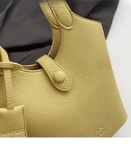 Dettaglio della borsa in pelle martellata con chiusura magnetica e logo inciso