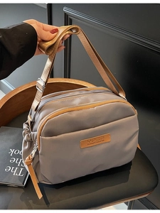 Dark gray multi-layer nylon crossbody bag with adjustable strap and three zipper pockets