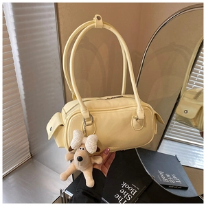 Détail d'un sac oreiller jaune crème en cuir brillant avec un charmant chien en peluche
