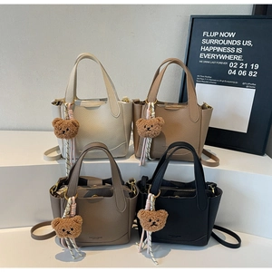 Detailed view of four colorful lychee pattern bucket bags with cute bear charms