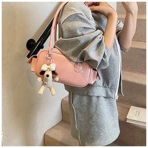 Détail du sac à bandoulière rose brillant avec un charmant pendentif en forme de chien