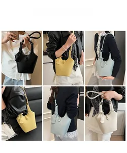 Dettaglio borsa a secchiello in pelle con trama litchi in vari colori e tracolla regolabile