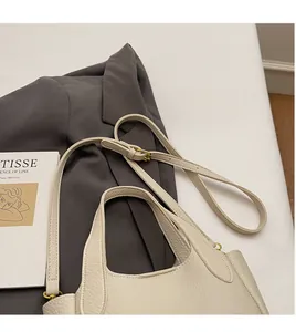 Detail of lychee pattern leather bucket bag with adjustable strap and gold hardware