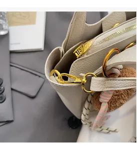 Detail of premium lychee texture leather bag with high-shine gold hardware accents