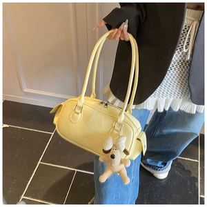 Vue détaillée du sac polochon en cuir jaune lisse avec un charmant chien en peluche
