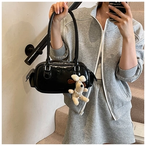 Vue détaillée d'un sac à main en cuir verni noir brillant avec un charmant pendentif
