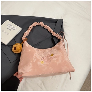Dettaglio della borsa hobo rosa con manico a nuvola e ciondolo a forma di orso