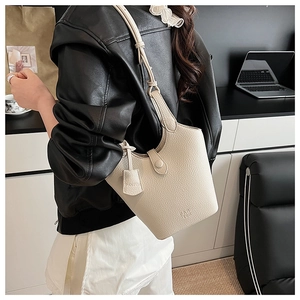 Dettaglio borsa a secchiello in pelle litchi bianco sporco con tracolla e logo inciso