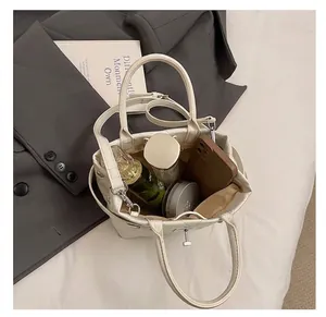 Capacité interne du sac seau matelassé blanc montrant téléphone et cosmétiques
