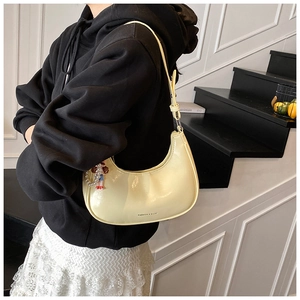 Pale yellow crescent underarm bag in glossy leather with adjustable strap and pearl charm