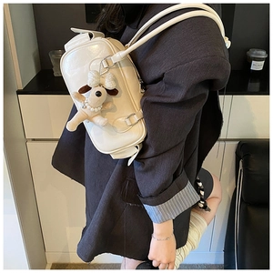 Détail du sac à bandoulière blanc avec fines lanières et pendentif petit chien en peluche