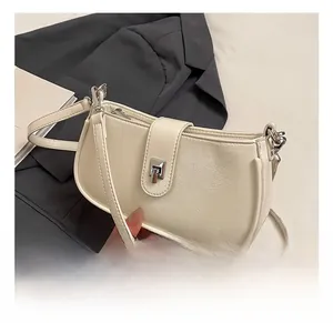 Detail of off-white lychee pattern leather shoulder bag with silver metallic buckle closure