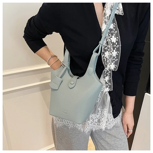 Dettaglio della borsa a secchiello celeste con texture in pelle a grana fine